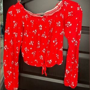 Red floral crop top. Long sleeve, tie front. Adjustable band across the top. MED